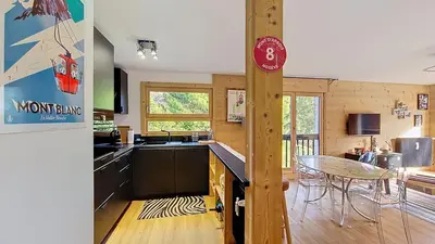 a kitchen and dining room with a table and chairs at 1 Riante Colline Arnica - PROCHE CENTRE in Megève