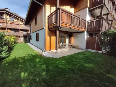 an apartment building with a patio and a yard at Rent cozy apartment sleeps 6 in SAMOENS in Samoëns