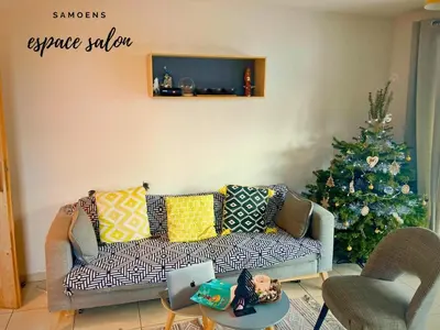 a living room with a couch and a christmas tree at Rent cozy apartment sleeps 6 in SAMOENS in Samoëns