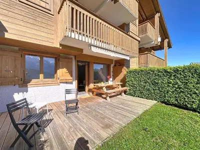 a wooden deck with two chairs and a wooden table at Appartement 2 pièces avec coin montagne, parking, vue Mont Blanc - FR-1-560-167 in Combloux