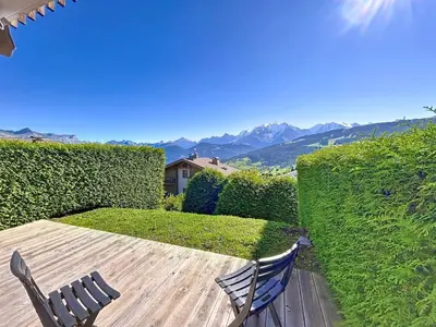 a patio with two chairs and a table with mountains in the background at Appartement 2 pièces avec coin montagne, parking, vue Mont Blanc - FR-1-560-167 in Combloux