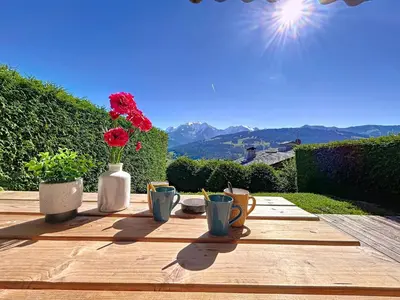 a wooden table with cups and flowers on top of it at Appartement 2 pièces avec coin montagne, parking, vue Mont Blanc - FR-1-560-167 in Combloux