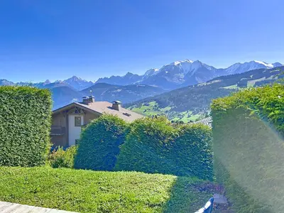 a house with hedges and a view of mountains at Appartement 2 pièces avec coin montagne, parking, vue Mont Blanc - FR-1-560-167 in Combloux