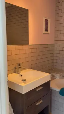 a bathroom with a sink and a mirror and a tub at Appartement familial cosy proche centre in Chamonix-Mont-Blanc