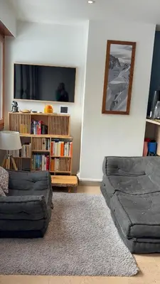 a living room with a couch and a book shelf at Appartement familial cosy proche centre in Chamonix-Mont-Blanc
