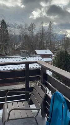 a chair sitting on top of a balcony with snow at Appartement familial cosy proche centre in Chamonix-Mont-Blanc