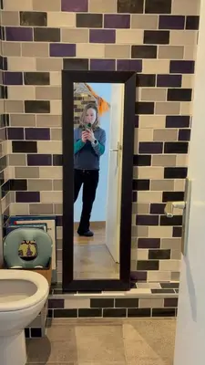 a woman taking a picture in a mirror in a bathroom at Appartement familial cosy proche centre in Chamonix-Mont-Blanc