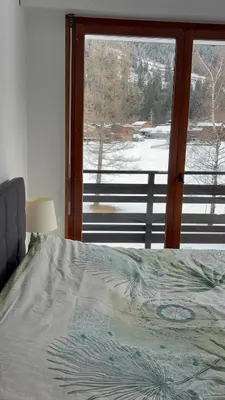 a bedroom with a bed and a window with a view at Appartement familial cosy proche centre in Chamonix-Mont-Blanc