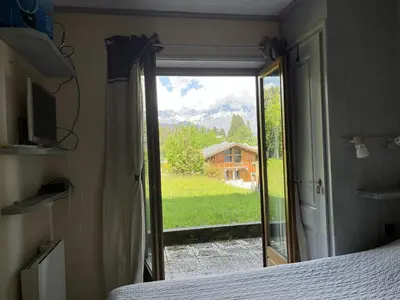 a bedroom with a sliding glass door with a view at Terrasse du MtBlanc in Combloux