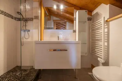 a white bathroom with a shower and a sink at Folettes Chalet 4CH Jardin Vue Cheminee Jacuzzi in Chamonix-Mont-Blanc