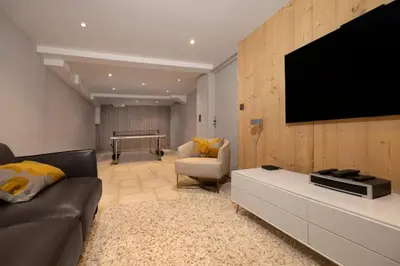 a living room with a couch and a flat screen tv at Folettes Chalet 4CH Jardin Vue Cheminee Jacuzzi in Chamonix-Mont-Blanc