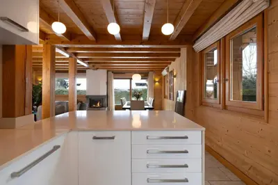 a kitchen with a white counter and a dining room at Folettes Chalet 4CH Jardin Vue Cheminee Jacuzzi in Chamonix-Mont-Blanc