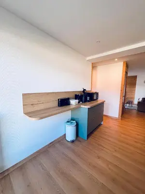 an empty room with a counter with two microwaves on a wall at L'écrin des quatre horizons in Saint-Gervais-les-Bains