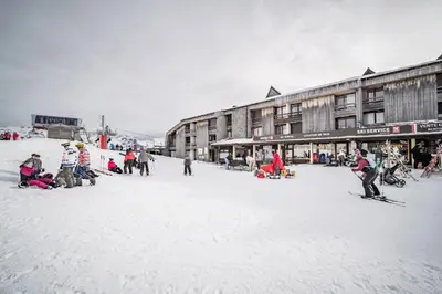 a group of people on skis in the snow in front of buildings at Appartement au pied des pistes - Vue imprenable in Samoëns