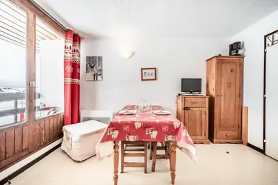 a dining room with a table and a red curtain at Appartement au pied des pistes - Vue imprenable in Samoëns