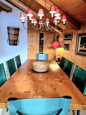 a dining room with a wooden table and chairs at A Soulful Alpine Retreat in Megève in Megève