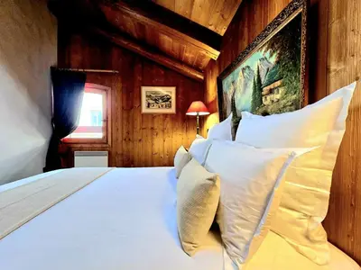 a bedroom with a large bed with white pillows at A Soulful Alpine Retreat in Megève in Megève