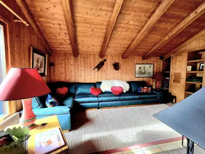 a living room with a blue couch and a red lamp at A Soulful Alpine Retreat in Megève in Megève