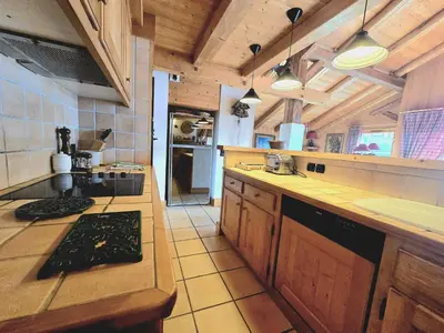 a large kitchen with wooden cabinets and a counter top at A Soulful Alpine Retreat in Megève in Megève