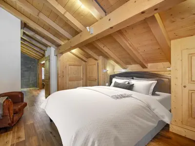 a bedroom with a white bed and wooden ceilings at Chalet de Luxe: 13 pers, Jacuzzi, Animaux Admis - FR-1-663-60 in Saint-Gervais-les-Bains