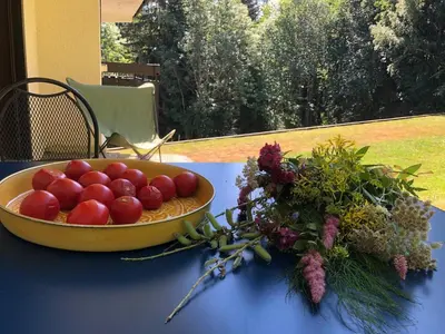 a bowl of tomatoes on a table next to a bouquet of flowers at Full nature, 4 people, Saint-Gervais, Chamonix in Saint-Gervais-les-Bains
