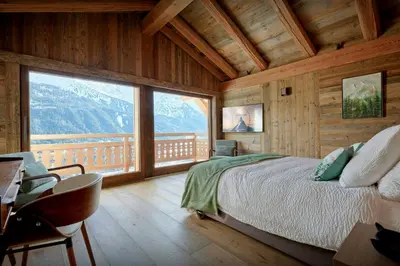 a bedroom with a bed and a large window at Chalet Lauda - OVO Network in Saint-Nicolas-de-Véroce