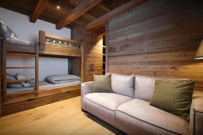 a living room with a couch and two bunk beds at Chalet Lauda - OVO Network in Saint-Nicolas-de-Véroce