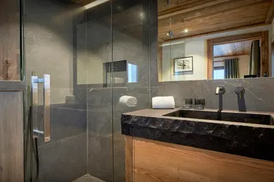 a bathroom with a sink and a glass shower at Chalet Lauda - OVO Network in Saint-Nicolas-de-Véroce