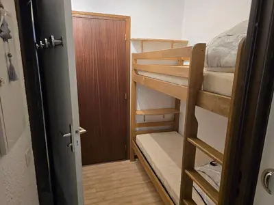 a room with two bunk beds and a door at Studio à 2 mn à pied des pistes de Mégève in Demi-Quartier