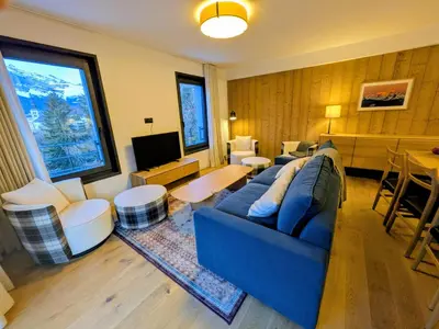 a living room with a blue couch and a table at Les Sources de Canopée A0105 By Avecoeur in Saint-Gervais-les-Bains