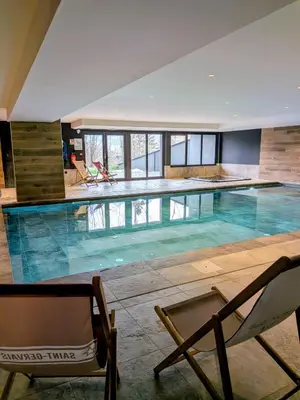 a large swimming pool with two chairs at Les Sources de Canopée A0105 By Avecoeur in Saint-Gervais-les-Bains