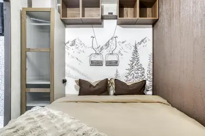 a bedroom with a bed and two ski lifts at Appartement F&F in Cordon