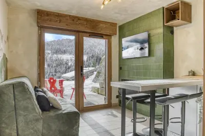 a kitchen with a table and chairs and a patio at Appartement F&F in Cordon