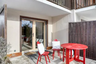 two chairs and a red table on a patio at Appartement F&F in Cordon