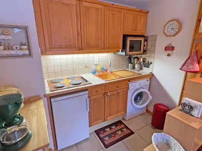 a small kitchen with a sink and a washing machine at Appartement T2 central avec balcon et casier à skis - FR-1-629-154 in Samoëns