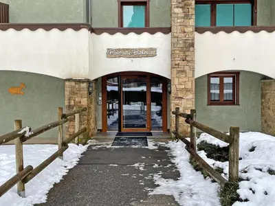 a front door of a building with snow on the ground at Appartement T2 central avec balcon et casier à skis - FR-1-629-154 in Samoëns