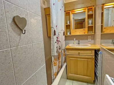 a bathroom with a sink and a shower curtain at Appartement T2 central avec balcon et casier à skis - FR-1-629-154 in Samoëns