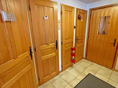 a hallway with two wooden doors and a tile floor at Appartement T2 central avec balcon et casier à skis - FR-1-629-154 in Samoëns