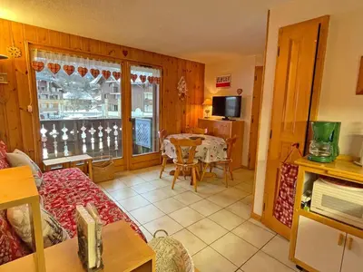 a living room with a table and a dining room at Appartement T2 central avec balcon et casier à skis - FR-1-629-154 in Samoëns
