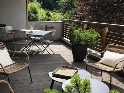 a deck with chairs and a table and a table and chairs at Appartement Familial 3 Pièces Pied de Piste avec Parking - FR-1-572-350 in Arâches-la-Frasse