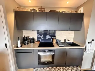 a kitchen with black cabinets and a sink at Appartement Familial 3 Pièces Pied de Piste avec Parking - FR-1-572-350 in Arâches-la-Frasse