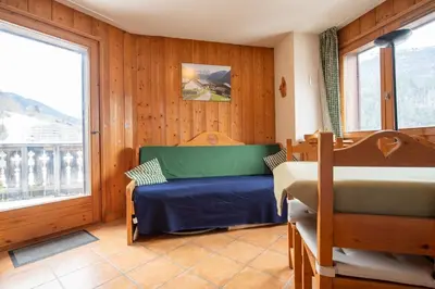a bedroom with two beds and a window at 2 bedroom, balcony and parking near Bellevue lift in Les Houches