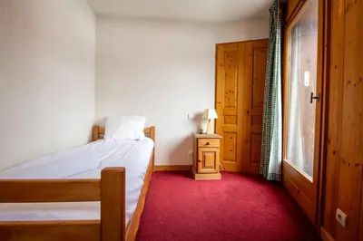 a bedroom with a bed and a table with a lamp at 2 bedroom, balcony and parking near Bellevue lift in Les Houches