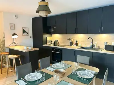 a kitchen with a table and a dining room at Renovated Flat At The Ski Bus Stop In Les Carroz in Arâches-la-Frasse