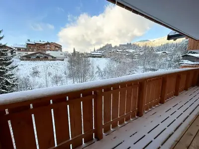 a snow covered balcony with a view of a town at Renovated Flat At The Ski Bus Stop In Les Carroz in Arâches-la-Frasse