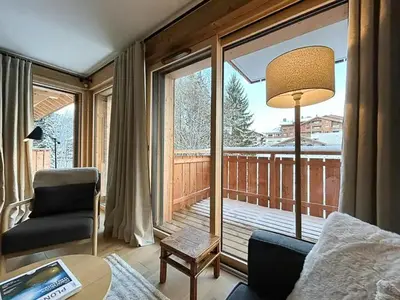 a living room with a view of a balcony at Renovated Flat At The Ski Bus Stop In Les Carroz in Arâches-la-Frasse