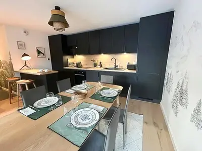 a kitchen and dining room with a table and chairs at Renovated Flat At The Ski Bus Stop In Les Carroz in Arâches-la-Frasse