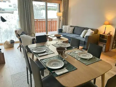 a living room with a table and a couch at Renovated Flat At The Ski Bus Stop In Les Carroz in Arâches-la-Frasse