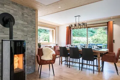 a dining room with a fireplace and a table and chairs at Appartement JASIONE-MEGEVE in Megève