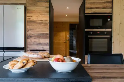 a kitchen with a table with bowls of food on it at Appartement JASIONE-MEGEVE in Megève
